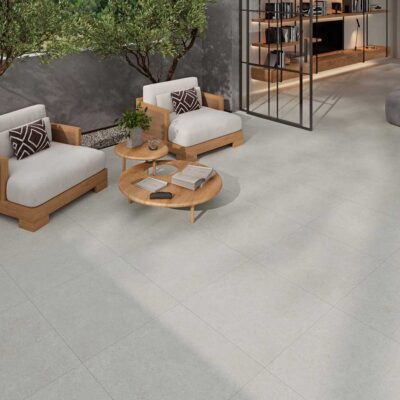 Patio exterior moderno con suelo porcelánico gris antideslizante y muebles de madera.