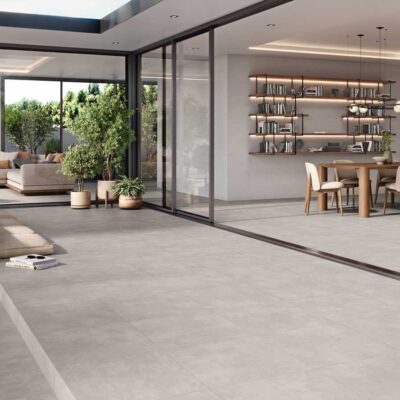 Amplio salón comedor con suelo porcelánico gris imitación cemento en un diseño moderno.