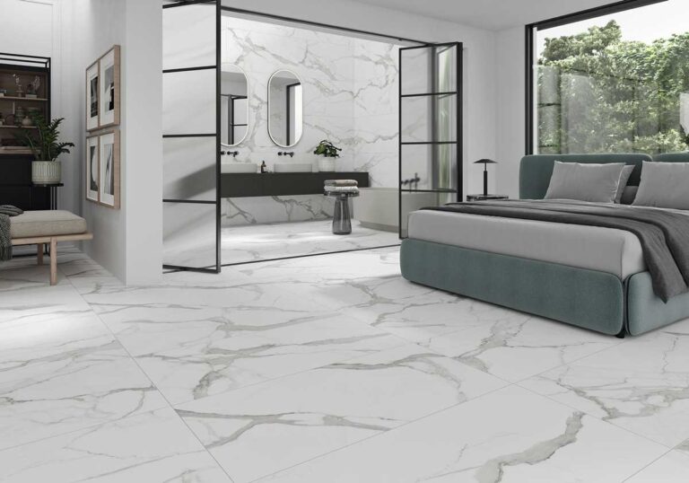 Dormitorio y baño modernos con suelo porcelánico imitación mármol blanco y vetas grises.