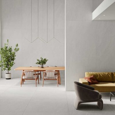 Suelo porcelánico Halton White efecto piedra claro en un salón comedor moderno.