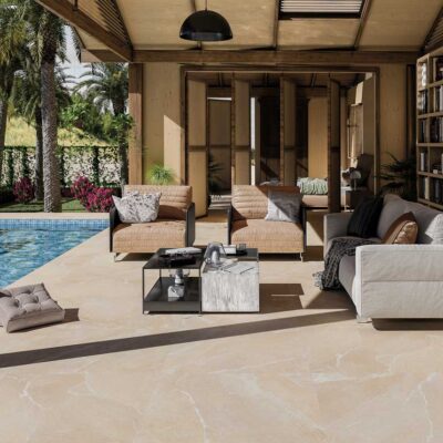 Suelo porcelánico Bodo Beige en una terraza exterior con piscina y palmeras.
