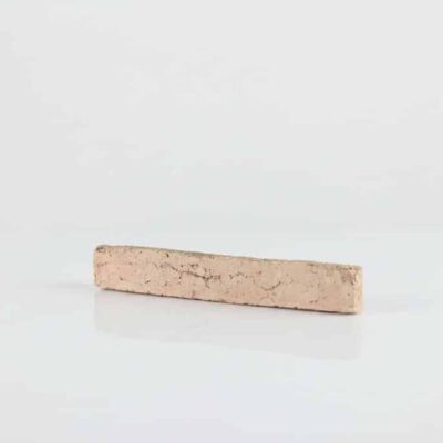 Pieza rectangular de ladrillo cerámico manual en tonos beige claro con textura rústica y acabado mate, formato alargado típico de revestimiento de pared.