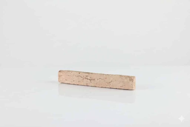 Pieza rectangular de ladrillo cerámico manual en tonos beige claro con textura rústica y acabado mate, formato alargado típico de revestimiento de pared.