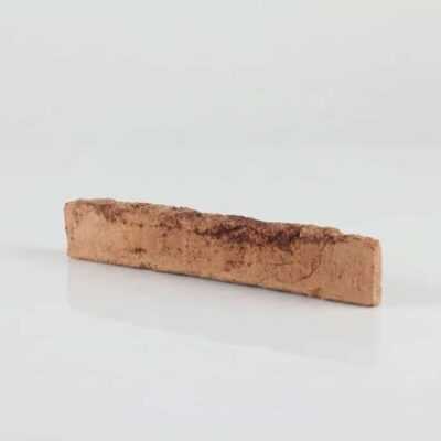 Pieza rectangular de barro cocido con superficie texturizada en tonos cálidos salmón y marrón. Acabado rústico y mate characteristic de la baldosa de terracota enarenada.