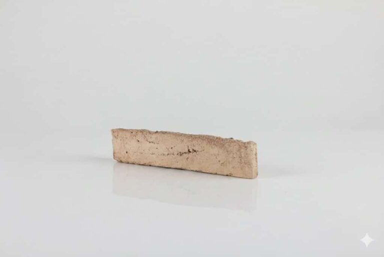 Pieza rectangular de baldosa cerámica con acabado enarenado en tonalidad salmón, superficie texturizada y mate, presentada sobre fondo neutro.