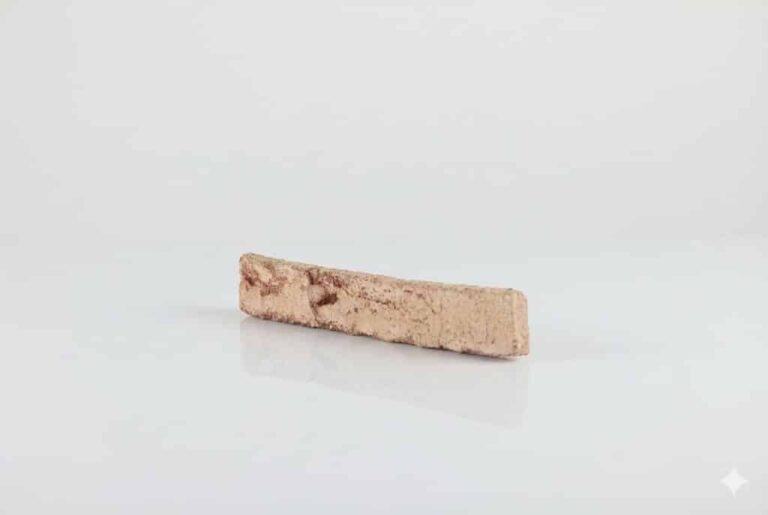 Pieza rectangular de baldosa cerámica con acabado enarenado en tonalidad salmón, superficie rugosa y texturizada con puntos oscuros dispersos, apta para revestimiento de pared.