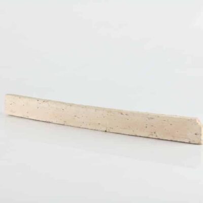 Rodapié rectangular extrusionado con acabado raspado y textura de corcho natural en tonos beige claro, mostrando la superficie rugosa característica del material.