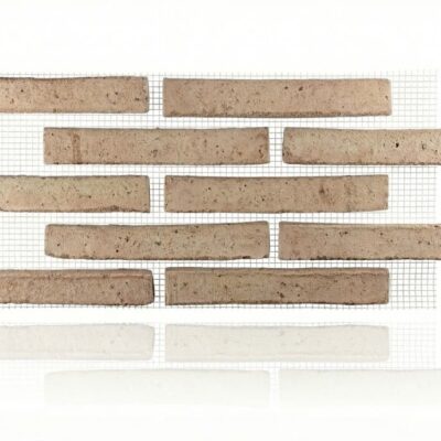 Piezas rectangulares de aplacado rústico en tono blanco con textura irregular y acabado mate, dispuestas horizontalmente sobre fondo neutro con cuadrícula de referencia.