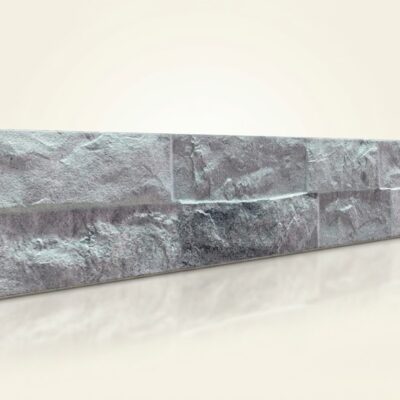 Baldosa cerámica rectangular con acabado efecto piedra en tonos grises moteados, superficie texturizada y mate que imita la apariencia natural de la piedra natural.