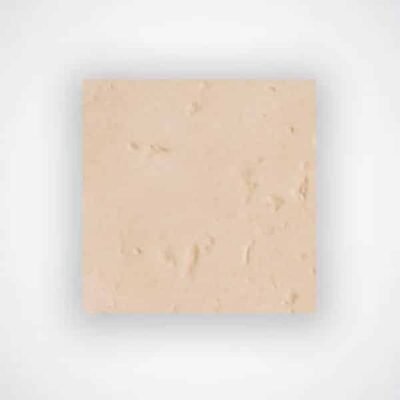 Pieza rectangular de baldosa cerámica en tonos beige cálido con textura rugosa imitación piedra natural y acabado mate.