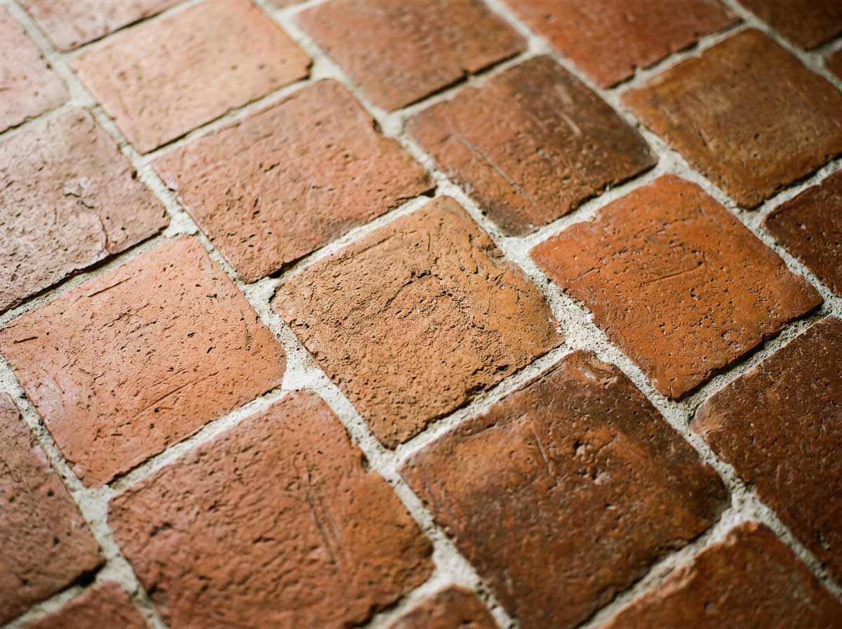 Detalle-de-un-suelo-de-barro-cocido-poroso-limpio-y-seco-con-textura-artesanal-tonos-terracota-naturales-y-juntas-visibles.jpg