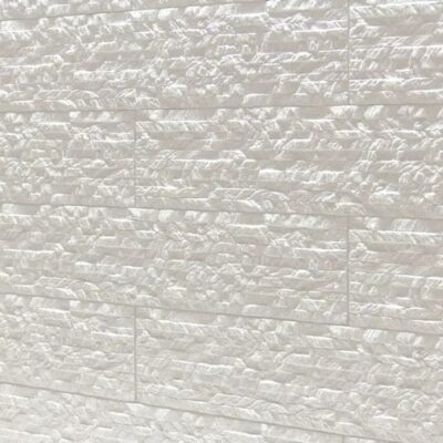 Superficie de gres cerámico con textura rugosa en tonos beige y crema, acabado mate con relieve detallado y variaciones de color natural.