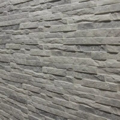 Superficie de gres cerámico con textura de piedra natural en tonos grises perla, acabado mate con relieve irregular y efecto pizarra.