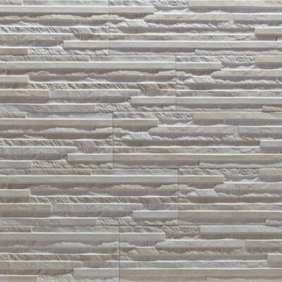 Superficie de gres cerámico con acabado mate y textura irregular imitando piedra natural en tonos crema y beige, mostrando relieves y variaciones de color características del suelo de gres.