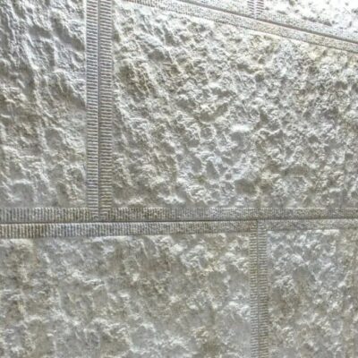 Cuatro muestras de gres cerámico Pirineos en tonos grises dispuestas en comparación. Cada pieza muestra textura rugosa de acabado mate con variaciones de color gris claro a gris medio, superficie con relieve microcementado y patrones de veining naturales.