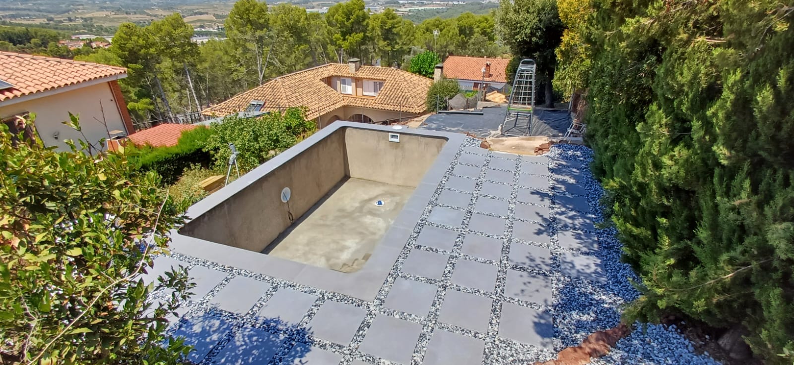 Terraza de piscina terminada con mobiliario exterior, demostrando la elegancia y amplitud del espacio.