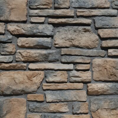 Piezas rectangulares de revestimiento con textura rústica imitación piedra natural en tonos beige, gris y marrón, dispuestas en patrón de despiece irregular con acabado mate y relieve pronunciado.