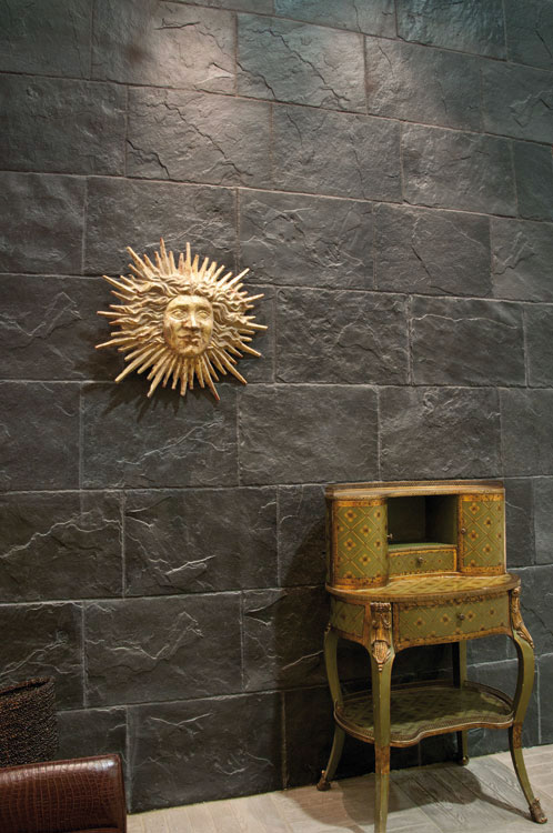 Pared de salón revestida con paneles de hormigón de estilo pizarra, aportando un toque industrial y sofisticado.