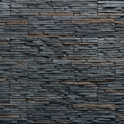 Superficie de revestimiento con textura de piedra laminada en tonos gris oscuro y marrón rojizo, mostrando capas horizontales irregulares y acabado mate con relieve pronunciado.