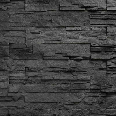 Superficie de revestimiento con textura de piedra natural irregular en tonos grises oscuros, piezas alargadas de diferentes tamaños dispuestas en patrón de sillería, acabado mate con relieve táctil pronunciado.