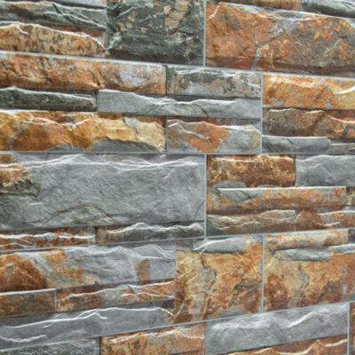 Dos muestras de revestimiento de pared en formato rectangular stacked: una en pizarra natural gris oscuro con textura rugosa y acabado mate, y otra en piedra reconstituida con tonos cálidos marrones y ocres con vetas simuladas. Ambas presentan acabado irregular característico de efecto piedra natural.