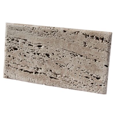 Pieza rectangular de aplacado en hormigón con textura rugosa imitando piedra travertino en tonos beige y gris oscuro, acabado mate con porosidad visible.