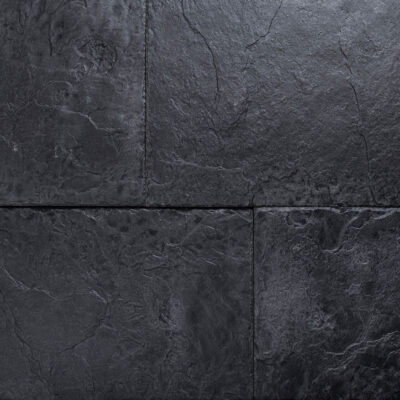 Superficie de pizarra con textura irregular y veteado natural en tonos gris oscuro, acabado mate. Grietas y relieve característico del material pétreo visible en todo el plano.