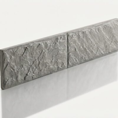 Baldosa cerámica rectangular con textura de piedra natural en tonos grises, acabado mate rugoso. Formato alargado, superficie con relieve que imita la piedra canteada.