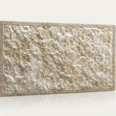 Baldosa cerámica rectangular con textura rugosa efecto piedra natural en tonos beige y gris claro, acabado mate y superficie irregular con relieve pronunciado.