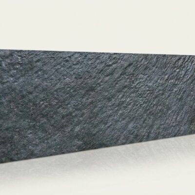 Baldosa cerámica rectangular con acabado mate que imita piedra natural, tonos grises oscuros con vetas irregulares y textura rugosa de relieve.