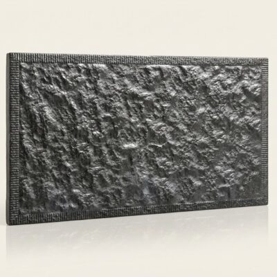 Baldosa cerámica rectangular con textura de piedra rugosa en tonos gris oscuro y gris claro, acabado mate. Bordes definidos con marco decorativo estriado.