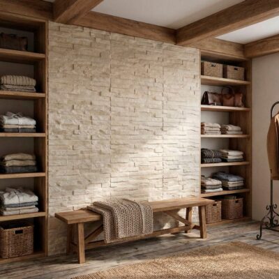 Vestidor con aplacado de pared imitación piedra en tonos crema, estanterías de madera con textiles y accesorios, banco de madera central y barra de ropa metálica lateral.
