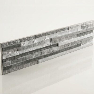 Pieza rectangular de azulejo con acabado efecto piedra en tonos grises y blancos, superficie con textura irregular y relieve que imita la piedra natural, formato alargado.