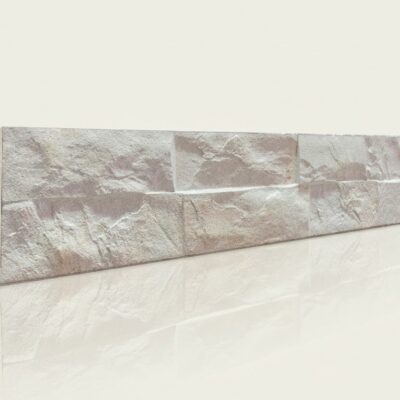 Pieza rectangular de azulejo con acabado imitación piedra en tonos marfil y beige, superficie texturizada y mate que simula la rugosidad natural de la piedra.