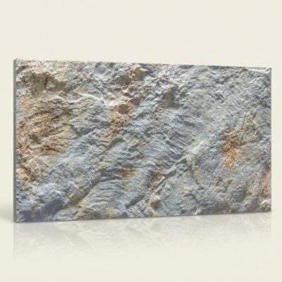 Baldosa cerámica rectangular con acabado efecto piedra natural en tonos perla y gris. Superficie texturizada con relieve que imita la irregularidad de la piedra volterra, con variaciones cromáticas sutiles entre beige, gris y tonos cálidos.