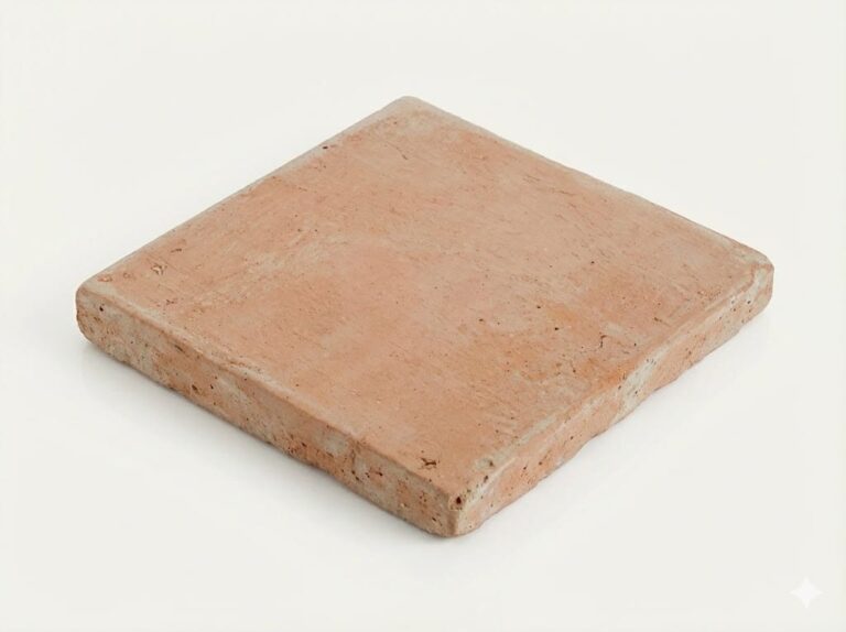 Baldosa cuadrada de barro cocido manual con formato 15x15 cm, superficie mate con textura rústica irregular y tonalidad tierra cálida, visible en los bordes el grosor característico del material artesanal.