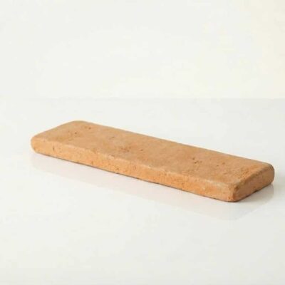 Pieza rectangular de barro cocido con superficie rústica y textura manual artesanal. Tono cálido beige-marrón claro, acabado mate y ligeramente irregular, característico de la terracota artesanal.