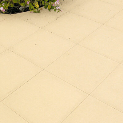 Baldosa de hormigón rectangular en tono crema con acabado mate uniforme y juntas visibles. Superficie lisa y homogénea, ideal para pavimentación de exteriores y terrazas.