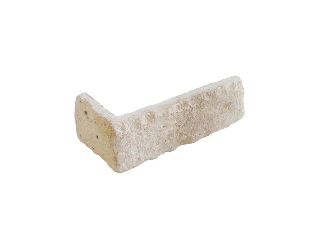 Pieza de esquina en hormigón con acabado imitación ladrillo color blanco polar, textura rústica rugosa, formato rectangular alargado para revestimiento de pared.