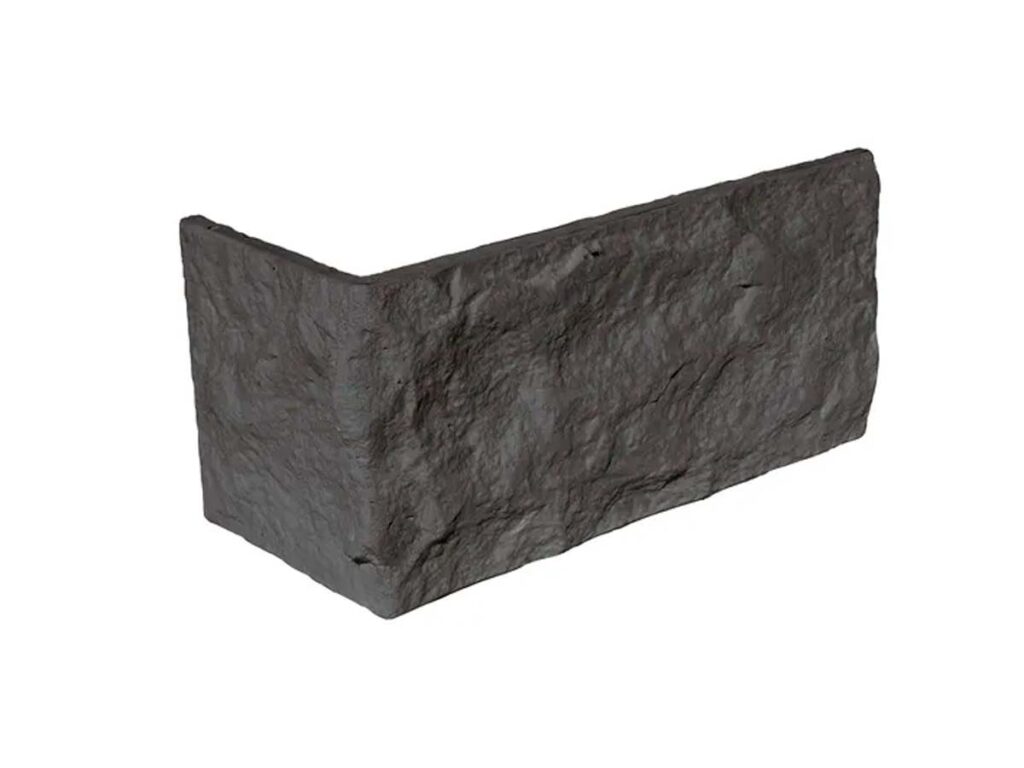 Pieza de esquina en acabado piedra natural con textura rugosa y color gris oscuro basalto. Formato angular para revestimiento de pared con superficie irregular y detalle de canteado.