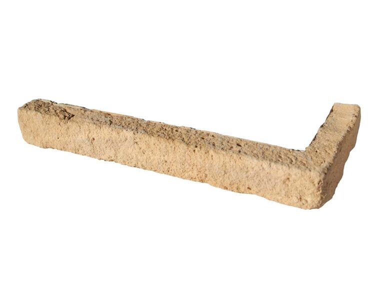 Pieza de esquina en formato L con textura rugosa que imita ladrillo cerámico, tonalidad cálida beige-arena con variaciones de color naturales, acabado mate rústico.