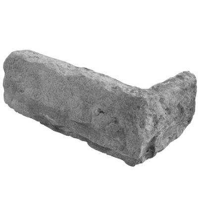 Pieza irregular de aplacado hormigón con textura rústica imitación piedra natural, tonos grises y ceniza con acabado mate y superficie rugosa.