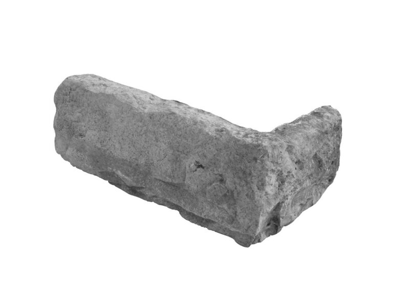 Pieza irregular de aplacado hormigón con textura rústica imitación piedra natural, tonos grises y ceniza con acabado mate y superficie rugosa.