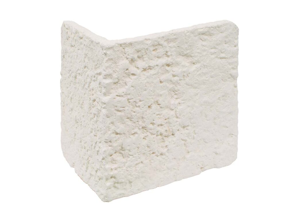 Pieza de aplacado de hormigón con textura rústica imitación piedra en tono crudo, formato esquinero, acabado mate con relieve natural.