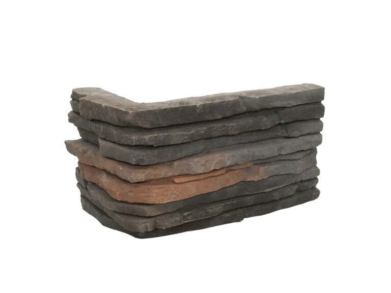 Piezas irregulares apiladas de aplacado en hormigón con efecto piedra natural en tonos grises y terracota, acabado rústico texturizado.