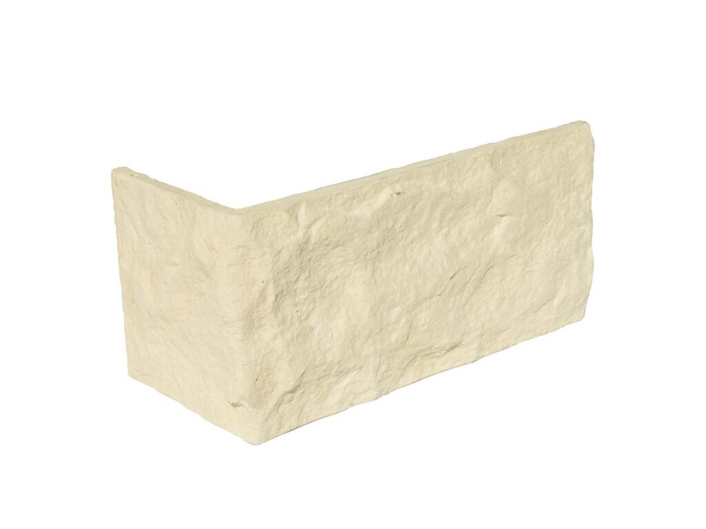 Pieza de revestimiento de hormigón con acabado texturizado imitación piedra natural en tonos crema y beige. Forma rectangular con aristas irregulares y superficie áspera de apariencia rústica.