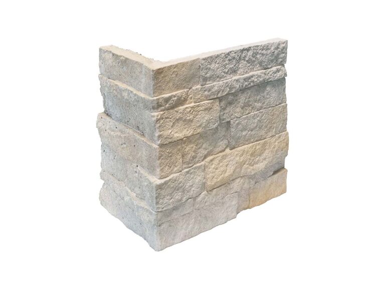 Esquina de aplacado en tono gris con textura de piedra natural, formada por piezas rectangulares superpuestas en disposición de mampostería. Acabado rústico y rugoso con variaciones tonales que imitan la piedra natural.