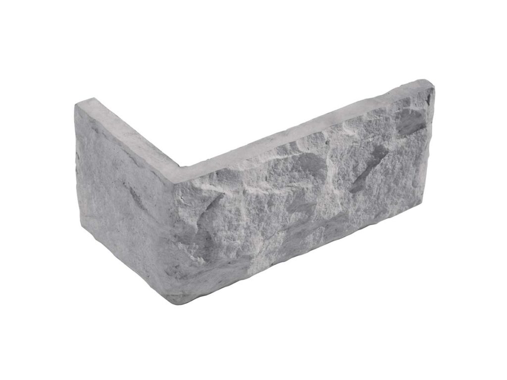 Pieza angular de aplacado con textura de piedra natural en tonos grises. Formato rectangular irregular con acabado rústico y superficie rugosa que imita la piedra canteada.
