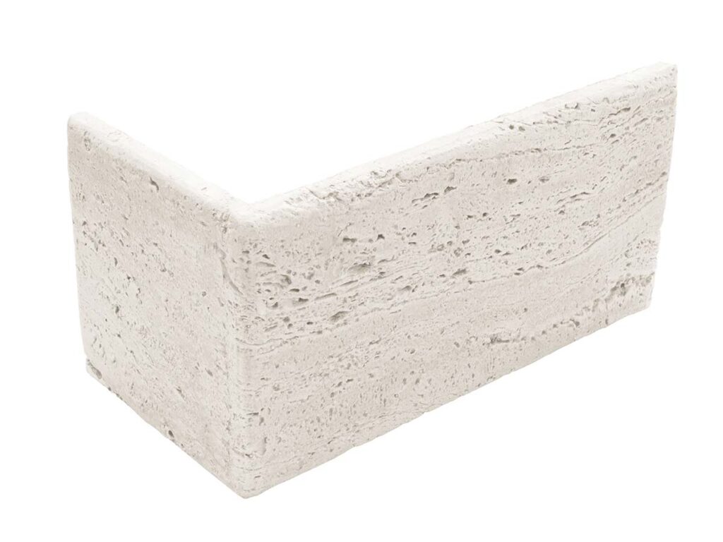 Pieza de aplacado en forma de esquina con textura rugosa imitación travertino en tonos crudo y beige claro, acabado mate con poros y vetas naturales del material.