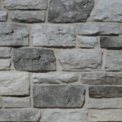 Panel de revestimiento rectangular con textura de piedra gris ceniza, superficie mate con relieve irregular que imita mampostería natural.